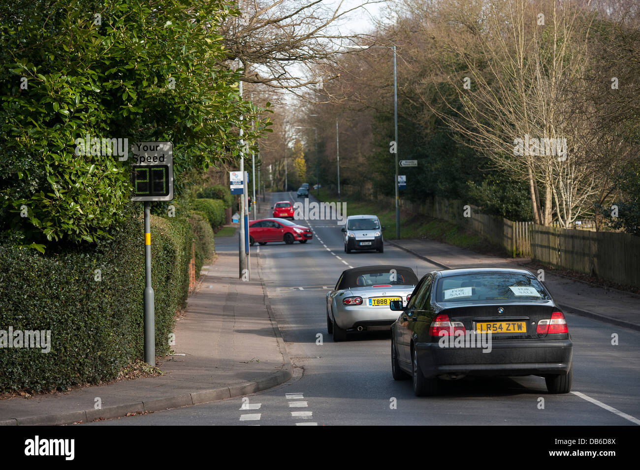 Traffic driving past a speed monitoring sign on a road in England. Stock Photo