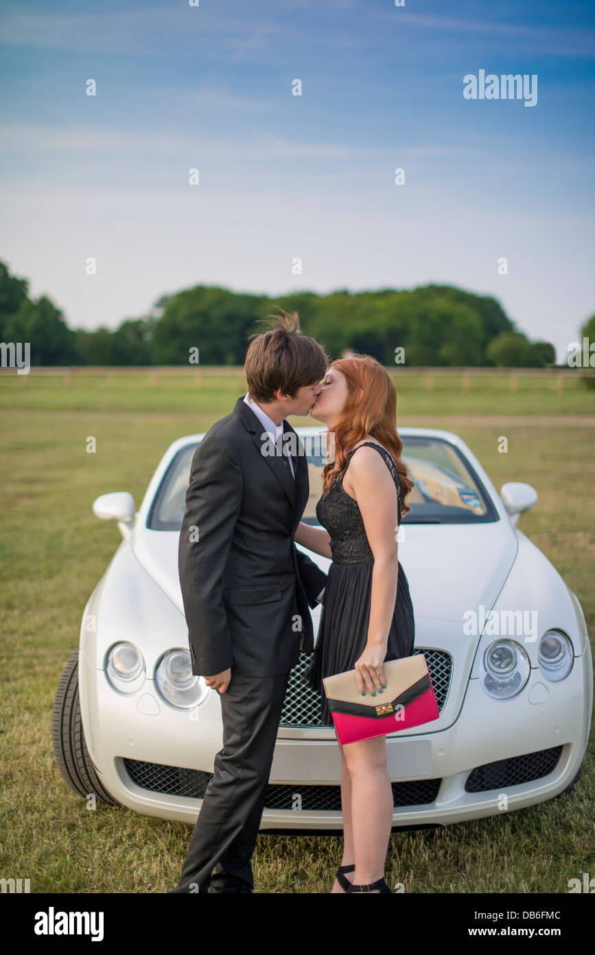 Prom kiss in front of luxury convertible Bentley car Stock Photo