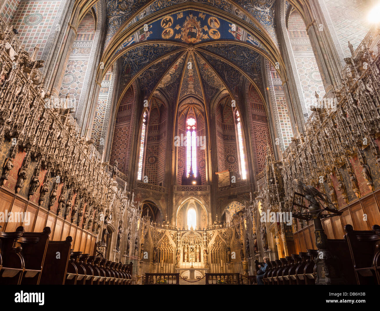 Choir and rear dome of the Cathedral. Detailed interior of the vast cathedral at Albi. A tourist takes one of the choir stalls Stock Photo