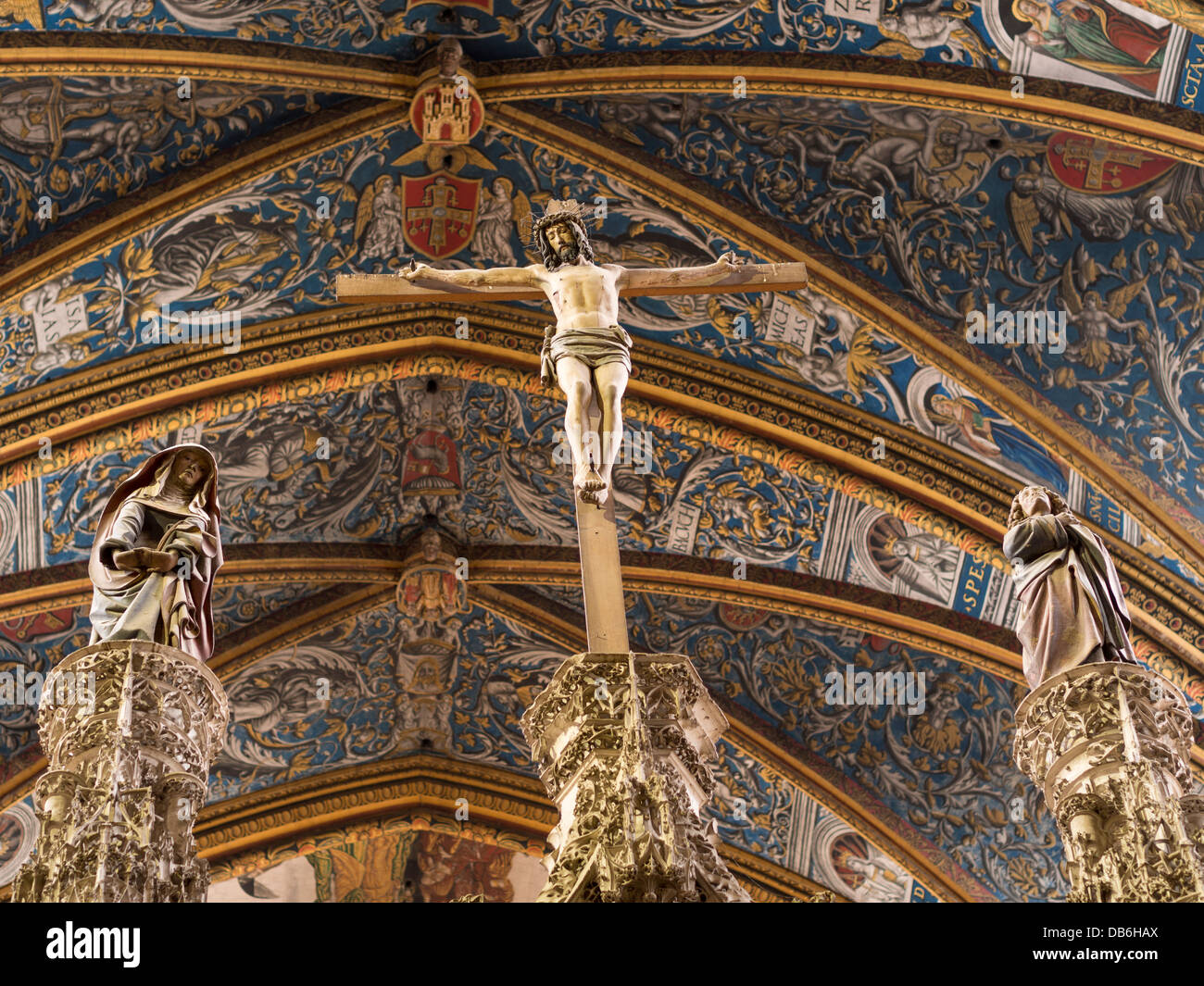 Crucified Christ above the Choir. A sculpture of Christ being crucified flanked by two saints Stock Photo