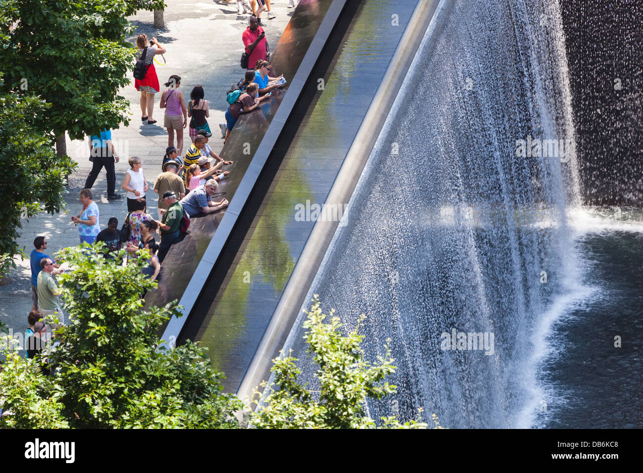 View to the World Trade Center 9/11 Memorial with tourists watching one of the two fountains. Stock Photo