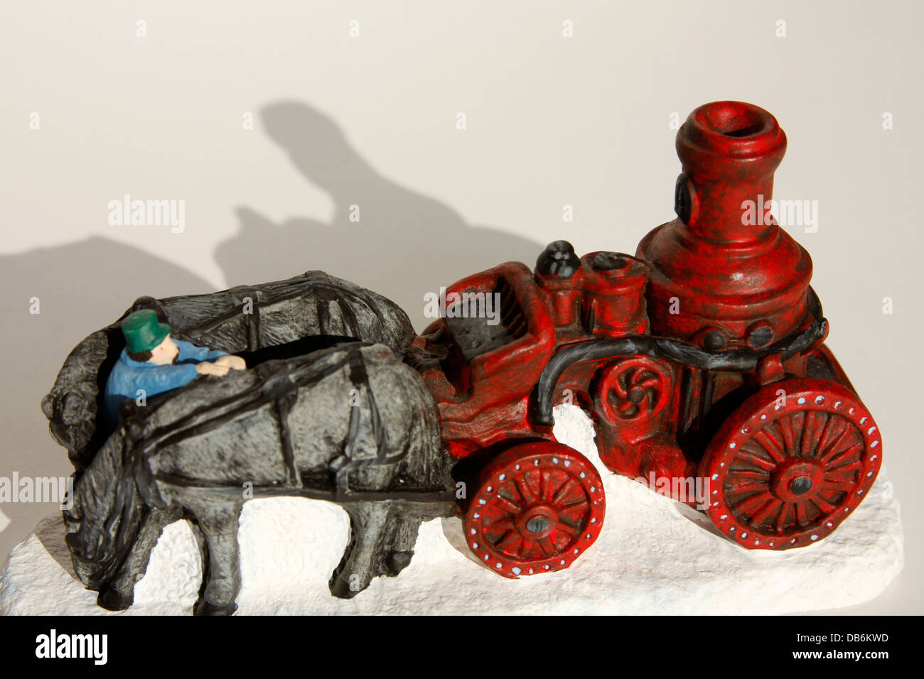 Ceramic figurine of an antique steam fire engine horse drawn wagon on white background Stock Photo