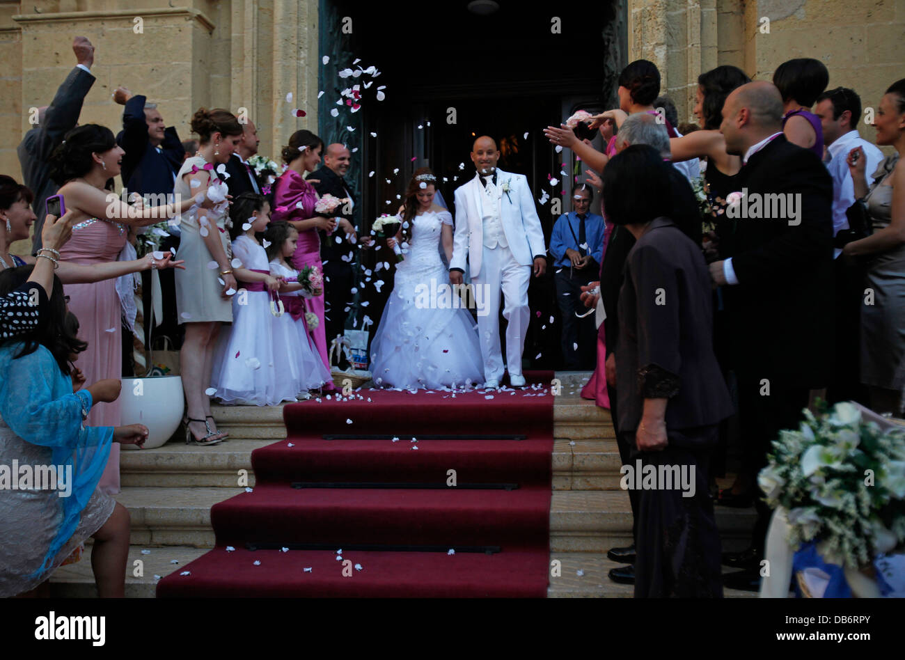 Guests throwing confetti over bride and groom during a Maltese wedding