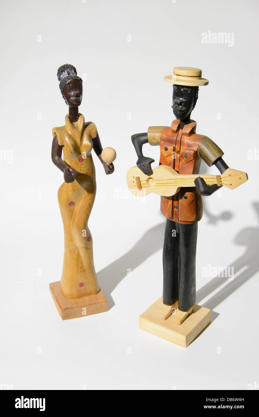 Carved wood musicians from Cuba.  A black woman dancing with a maraca and a black man with a guitar. Stock Photo