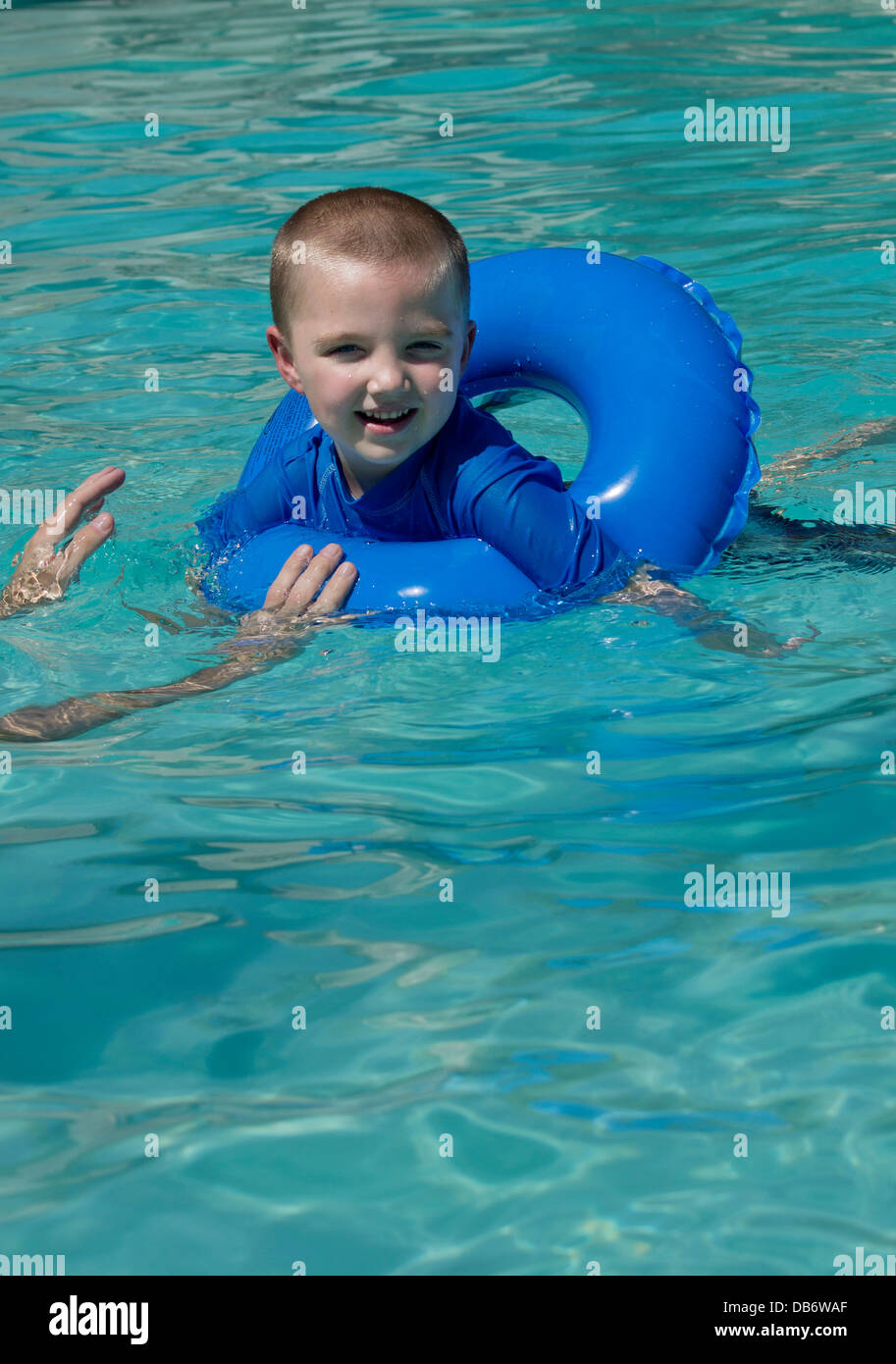 A six year old boy with autism smiles while playing with his dad in the