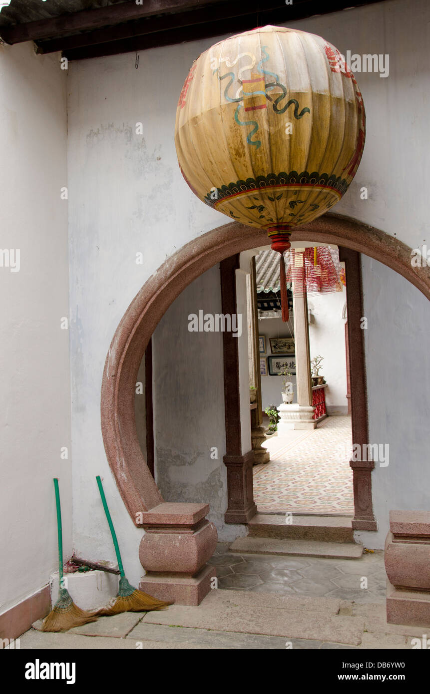 Vietnam, Hoi An. Assembly Hall of the Cantonese Chinese Congregation. Chinese style round doorway with lantern and brooms. Stock Photo