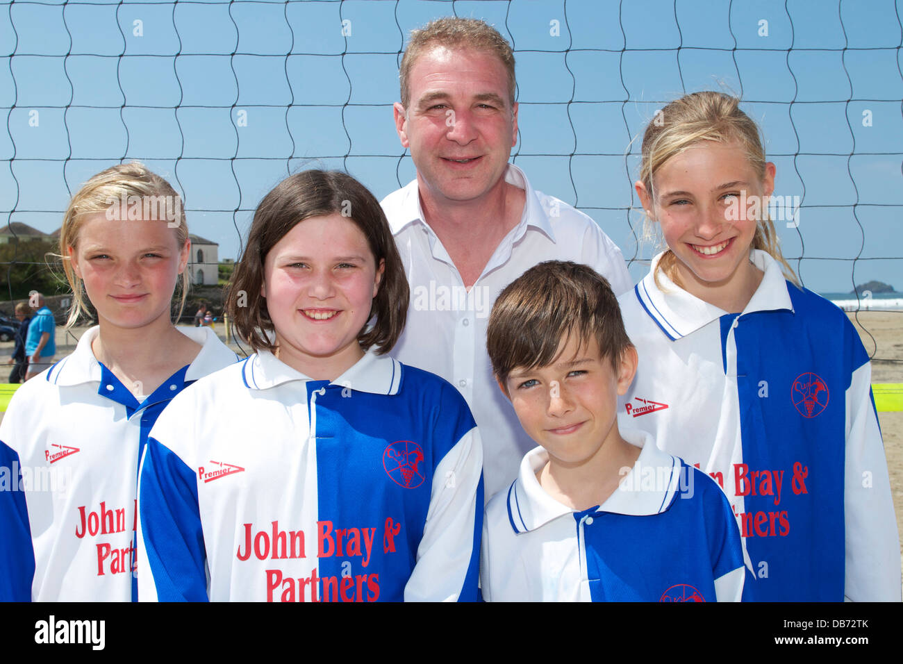 On Polzeath beach in the sun St Merryn youngsters and their Coach eagerly await match play Stock Photo