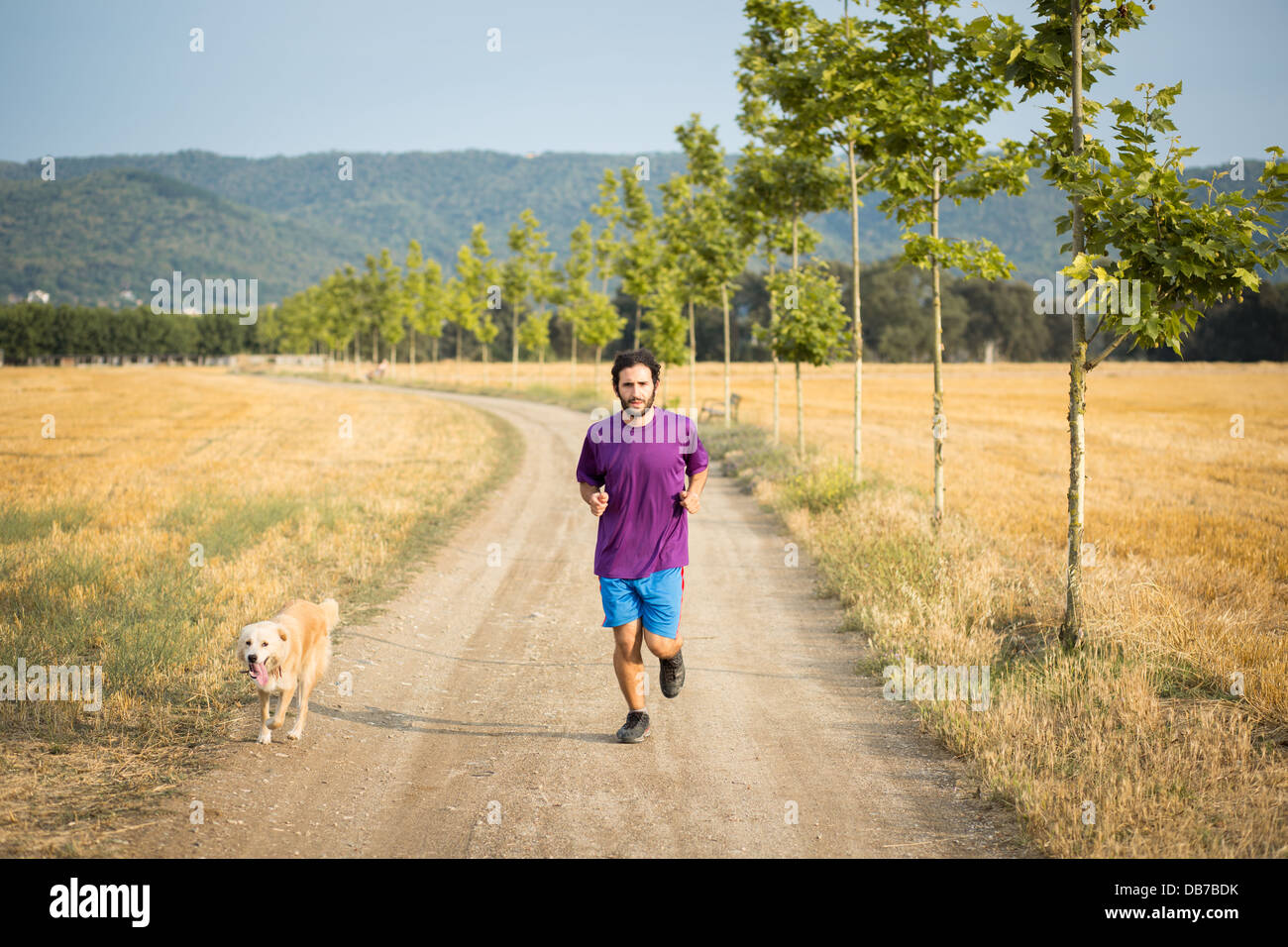 Guy running with a dog in the nature Stock Photo