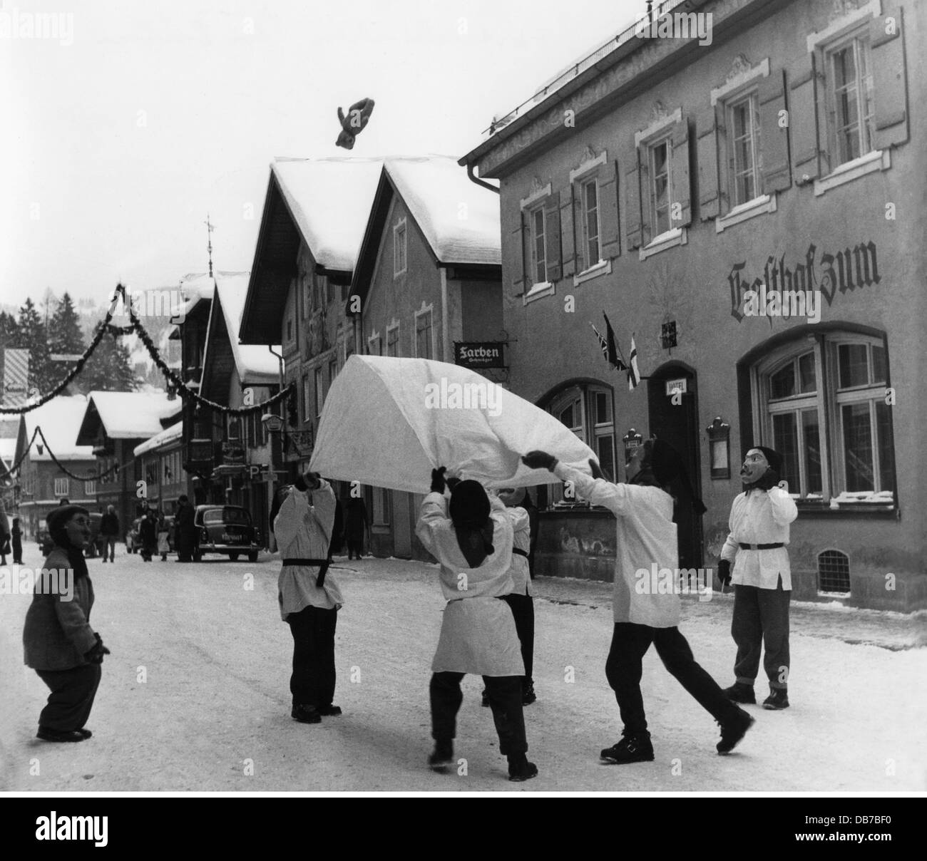 festivities, carnival at Partenkirchen, children with wooden masks throwing teddy bear with blanket in the air, Garmisch - Partenkirchen, 1956, Additional-Rights-Clearences-Not Available Stock Photo
