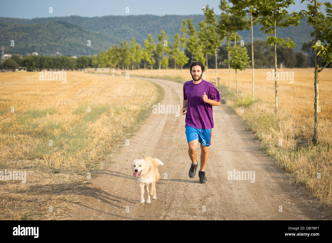 Guy running with a dog in the nature Stock Photo