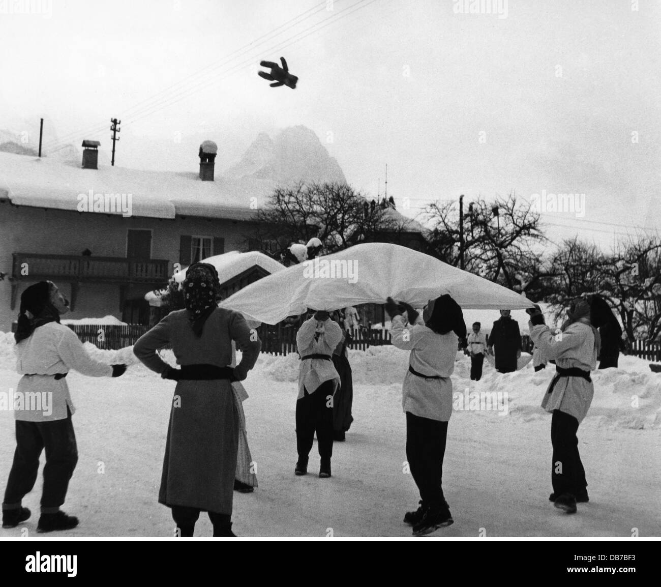 festivities, carnival at Partenkirchen, children with wooden masks throwing teddy bear with blanket in the air, Garmisch - Partenkirchen, 1956, Additional-Rights-Clearences-Not Available Stock Photo