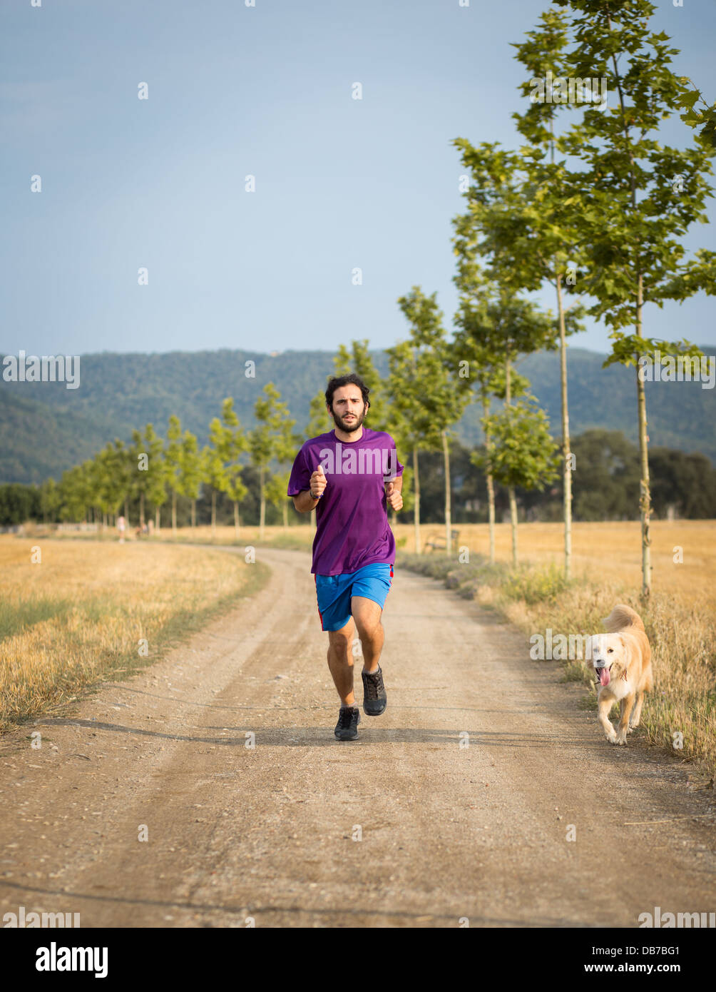 Guy running with a dog in the nature Stock Photo