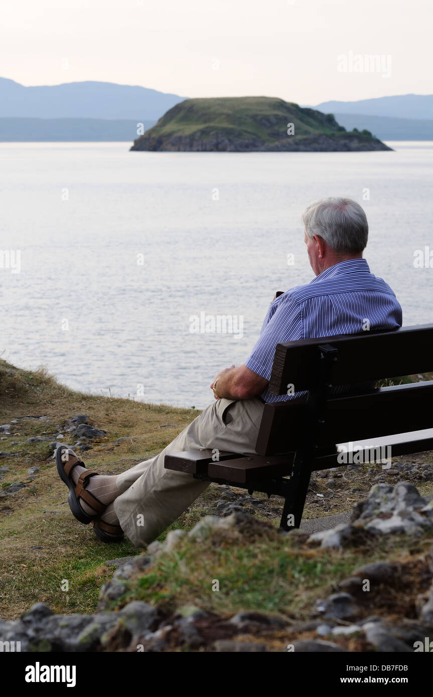 A man sitting on wooden bench outdoors Stock Photo - Alamy