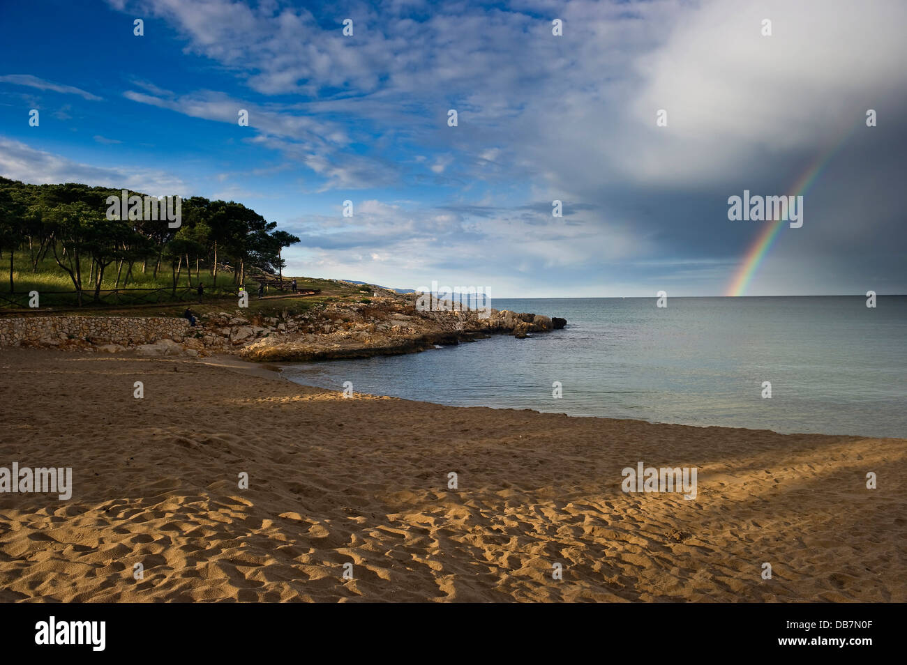 Sandy beach with rainbow over the sea Stock Photo
