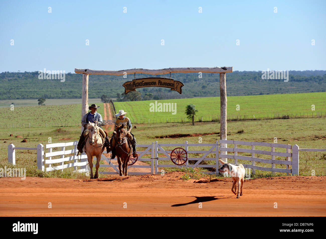 Two men riding horses, cowboys, entrance of a fazenda or ranch of a landowner Stock Photo