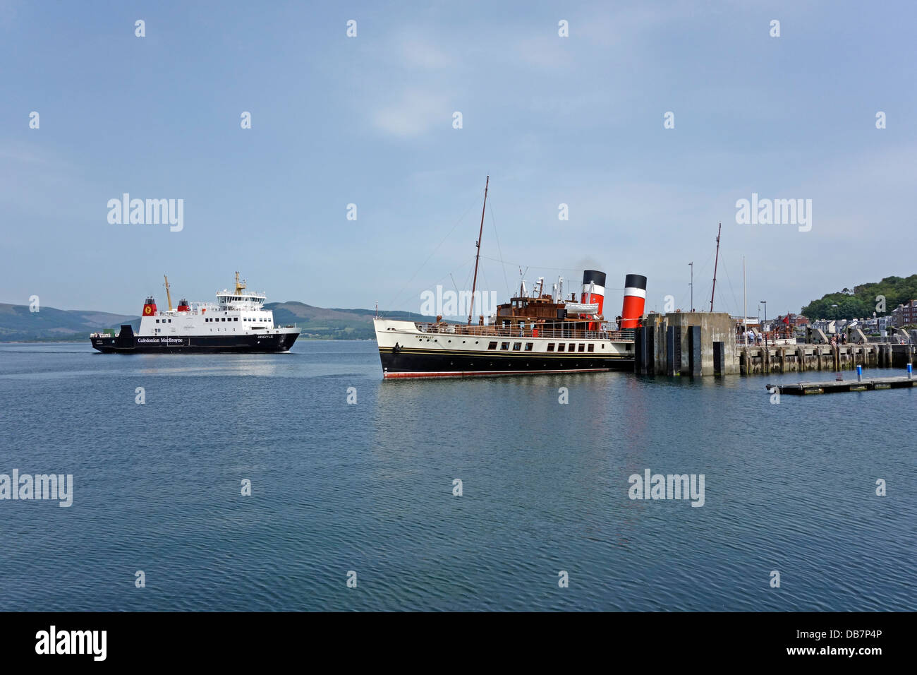 CalMac car & passenger ferry Argyle arrives at Rothesay on Bute Scotland from Wemyss Bay with paddle steamer Waverley at quay Stock Photo