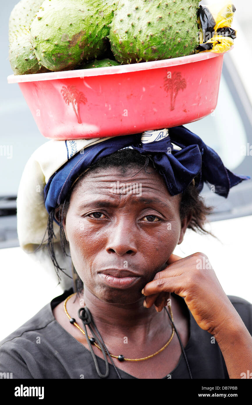 Market woman carrying fruit on her head Stock Photo