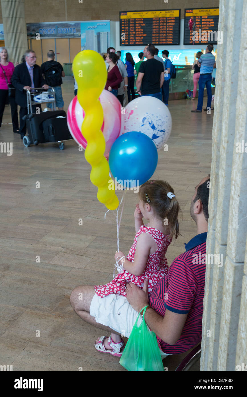 father and daughter waiting at the airport with balloons. Ben Gurion airport. Israel. Stock Photo