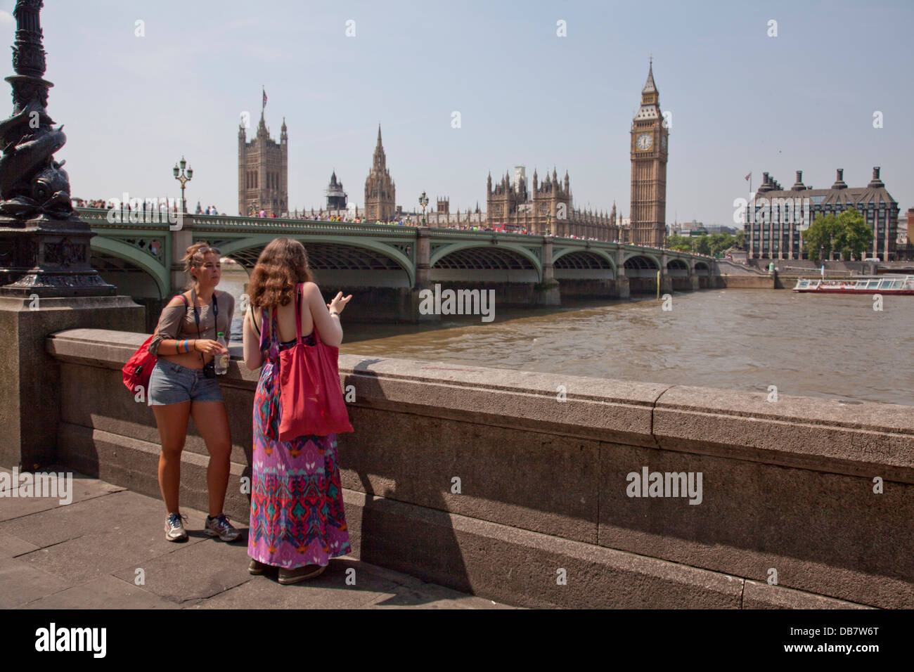 Young tourists by Thames river opposite Houses of Parliament in London Stock Photo