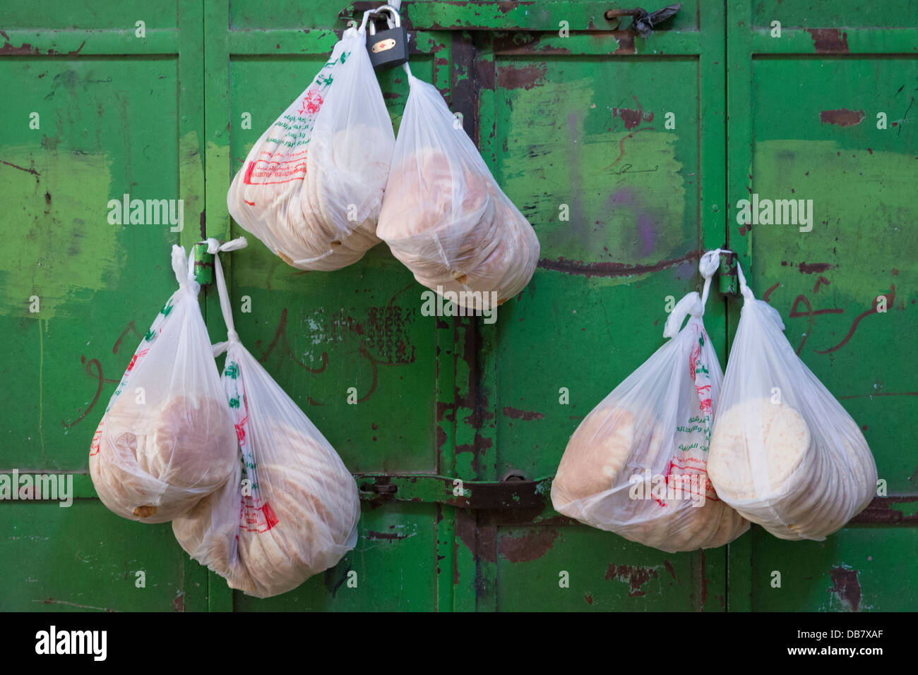 Pita bread in plastic bags hanging on the shutters of a closed restaurant. Jerusalem Old City. Israel. Stock Photo
