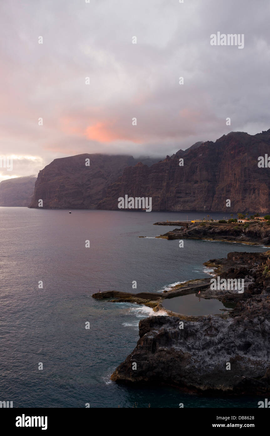 Los Gigantes cliffs, village, and coastline at dusk on a overcast summer day with deep rich colours reflecting the low light, Stock Photo