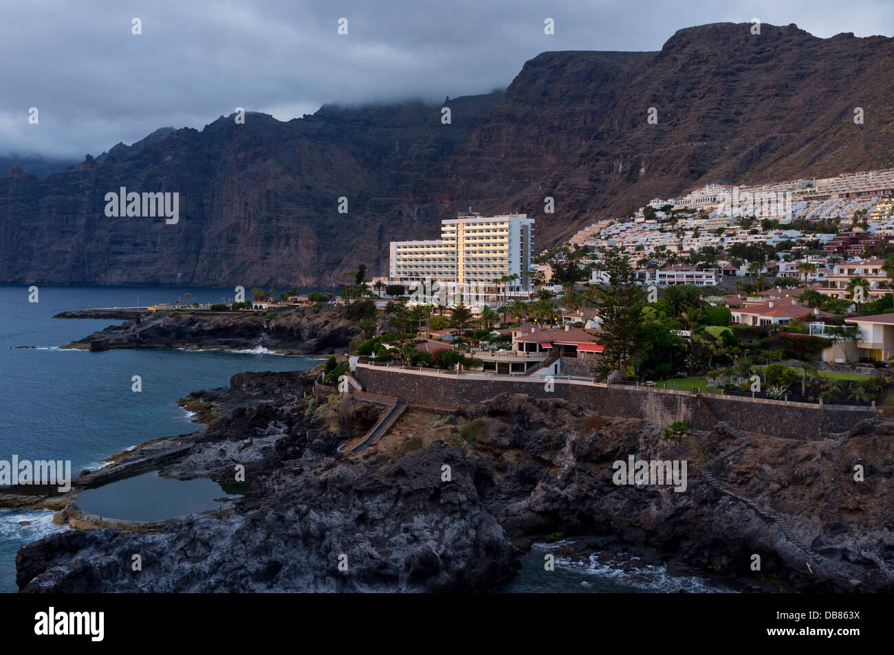 Los Gigantes cliffs, village, and coastline at dusk on a overcast summer day with deep rich colours reflecting the low light, Stock Photo