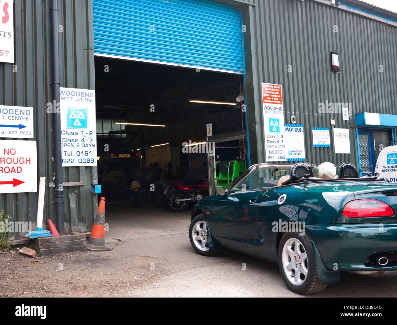 Elderly gentleman waiting for an MOT test in his sports car. England UK. Stock Photo