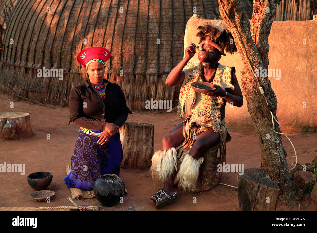 Zulu chief tasting beer in the traditional Zulu umuzi homestead at Shakaland, KwaZulu-Natal Stock Photo