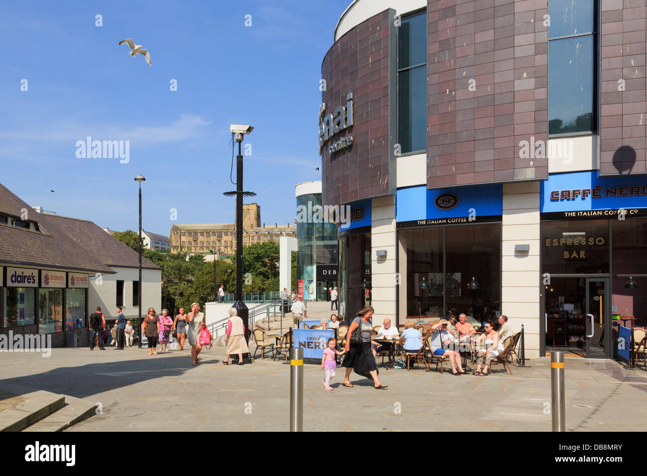 People sitting in sunshine outside Caffe Nero coffee shop in Plas Menai shopping centre in summer. Bangor, Gwynedd, Wales, UK, Britain Stock Photo