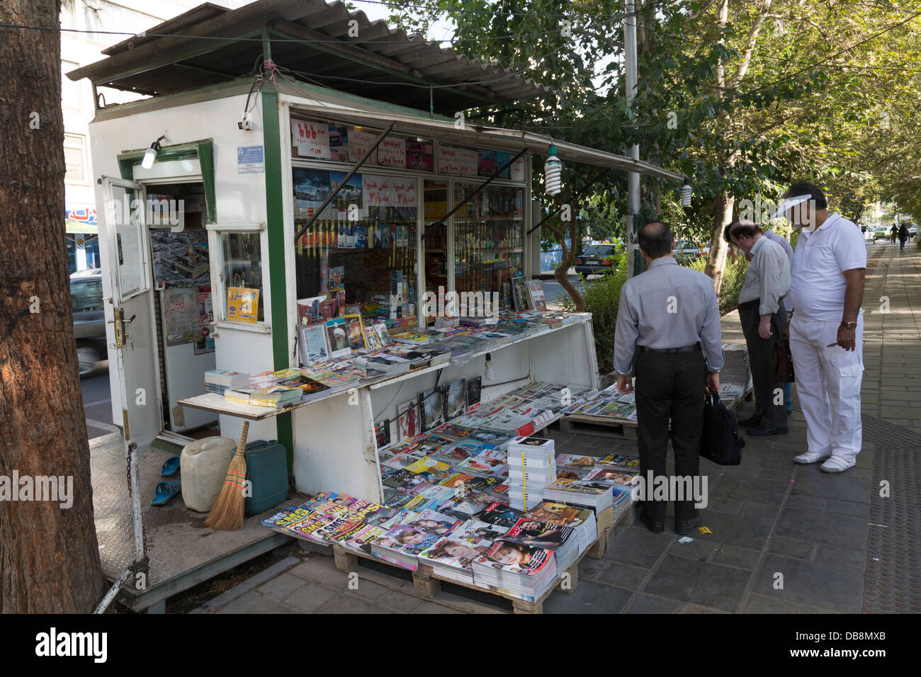 Iranian pedestrians reading newspaper headlines at news kiosk, Tehran, Iran Stock Photo