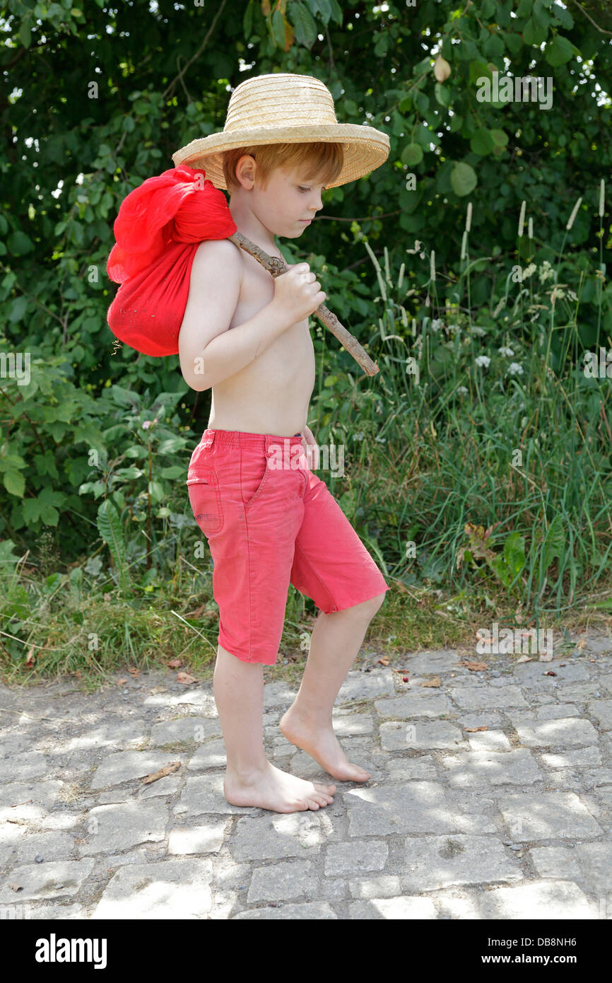 young boy with his bundle walking barefoot along a track Stock Photo ...