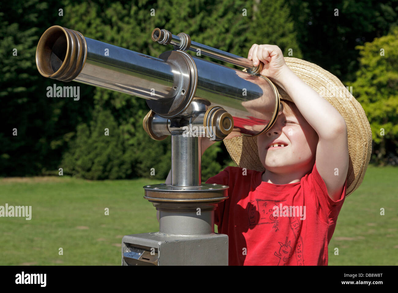 young boy looking through a telescope Stock Photo