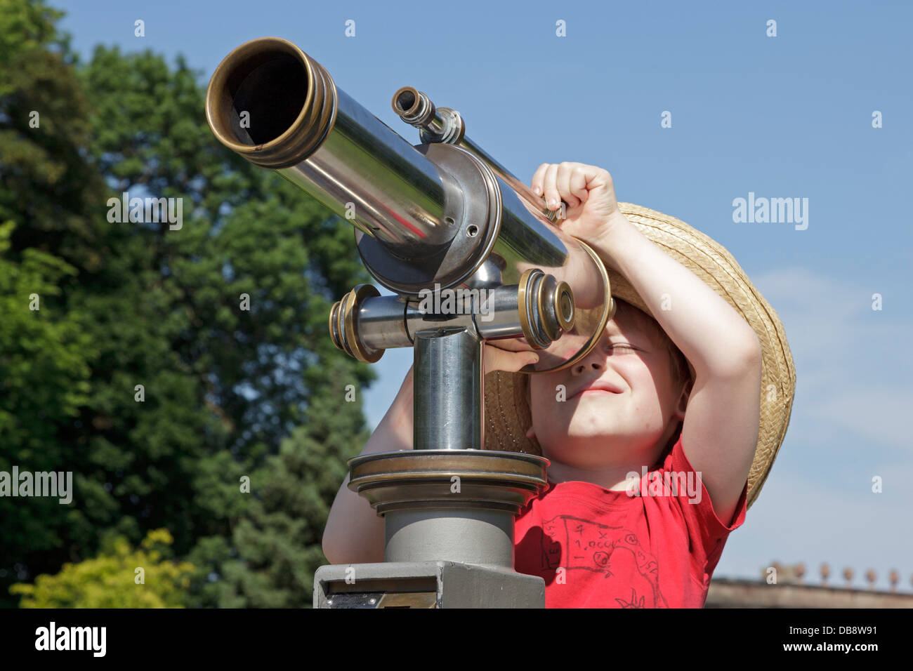 young boy looking through a telescope Stock Photo