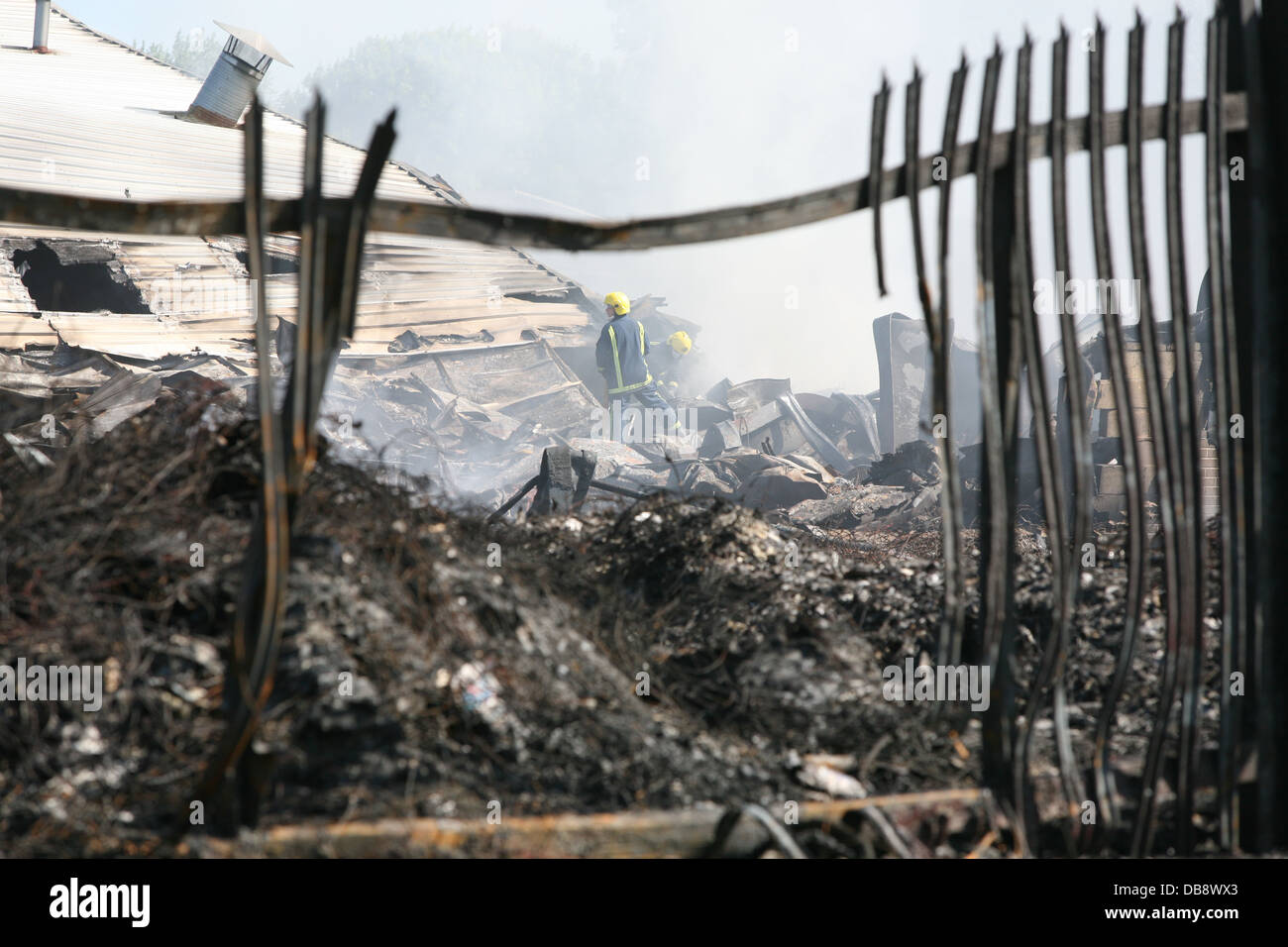 firefighters inspect a building that has been destroyed by fire Stock Photo