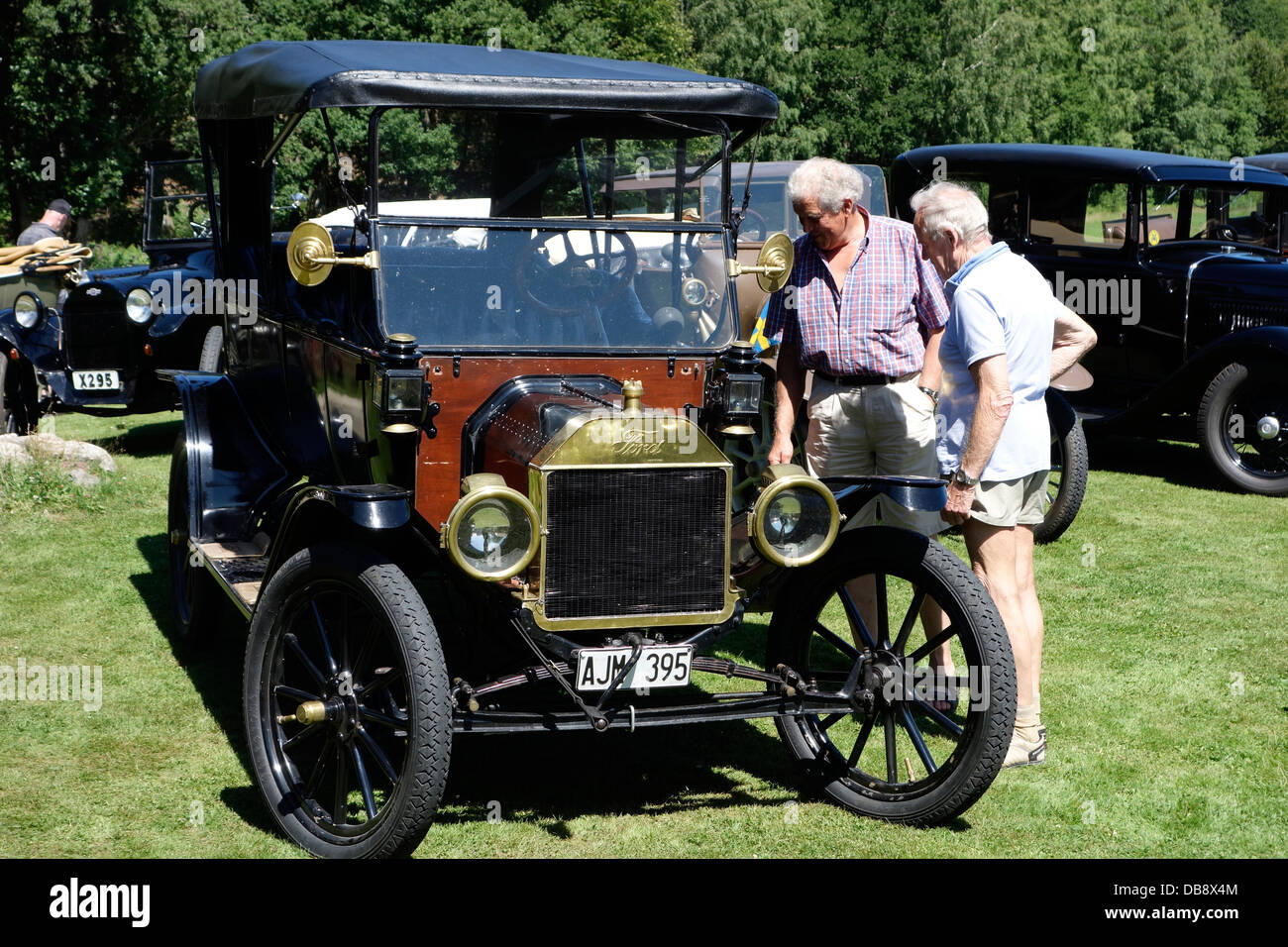 Antique cars meeting. Two senior men inspect an antique motorcar Ford T model from 1914. Stock Photo