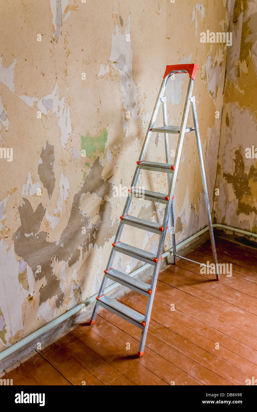 Old wallpapers and metallic ladder Stock Photo