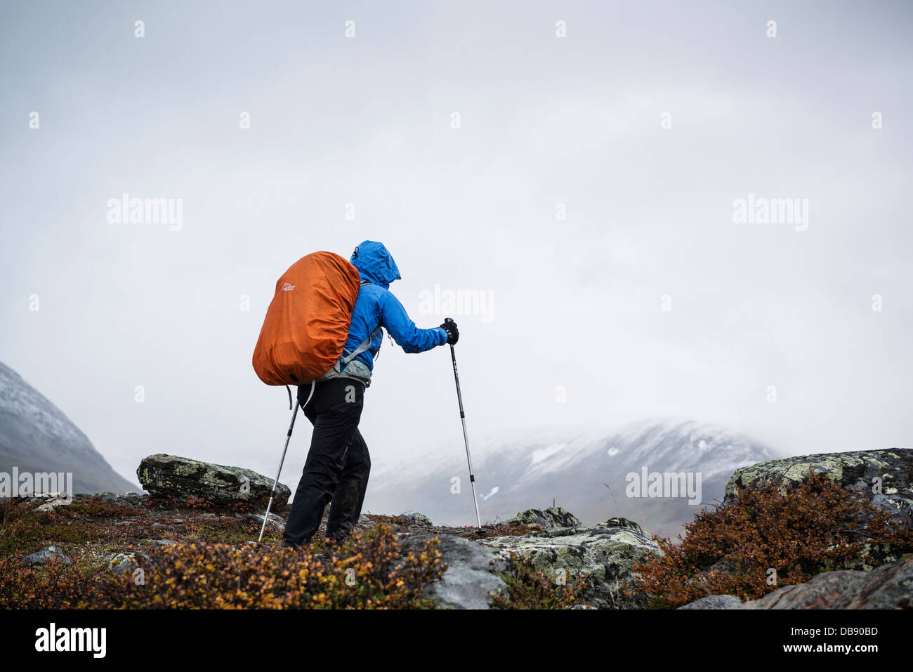 Female hiker in stormy weather in southern end of Tjäktjavagge on Kungsleden trail, Lappland, Sweden Stock Photo