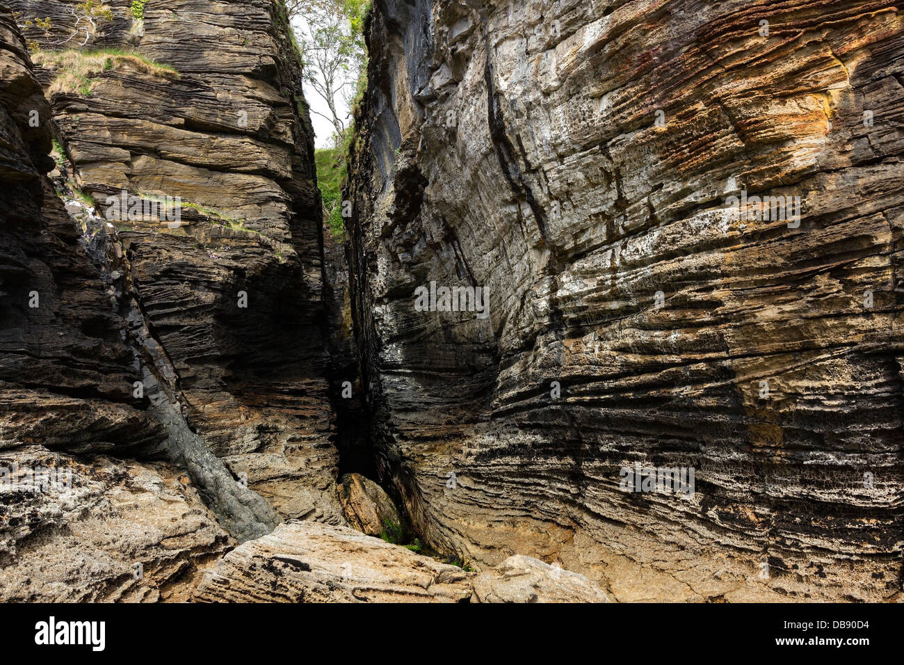 Dramatic eroded sedimentary rock strata and ravine in sea cliffs on approach to Spar Cave, Glasnakille, Isle of Skye, Scotland, UK Stock Photo