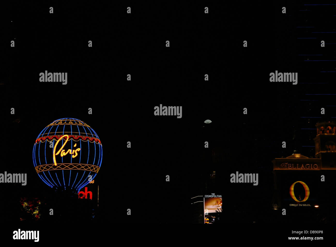 Blue neon Montgolfier Balloon rising night sky to Bellagio and Planet Hollywood, Paris Resort, The Strip, Las Vegas, Nevada, USA Stock Photo