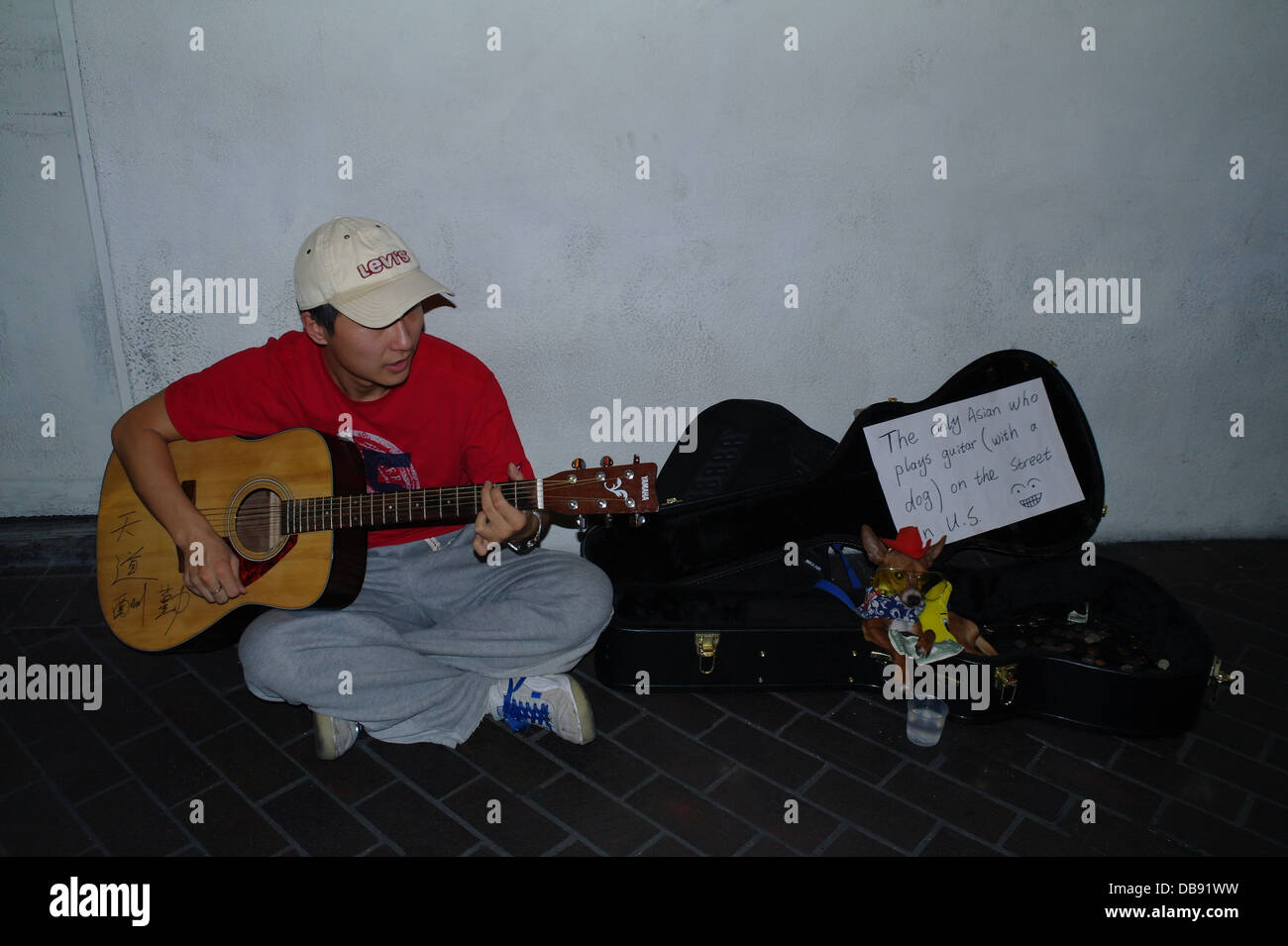 Night white wall view Oriental American sitting playing guitar, with