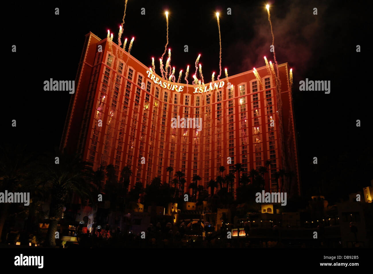 Fireworks exploding night sky above illuminated Treasure Island Hotel Casino, at end of Sirens Cove pirate show, Las Vegas Strip Stock Photo