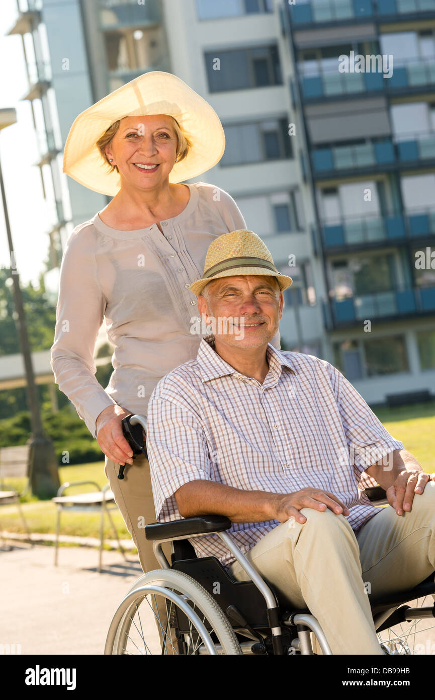 Wealthy senior man in wheelchair with wife retirement Stock Photo