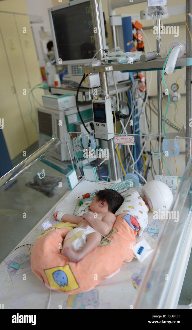 A newborn baby lies in a baby cot at the centre for infants with