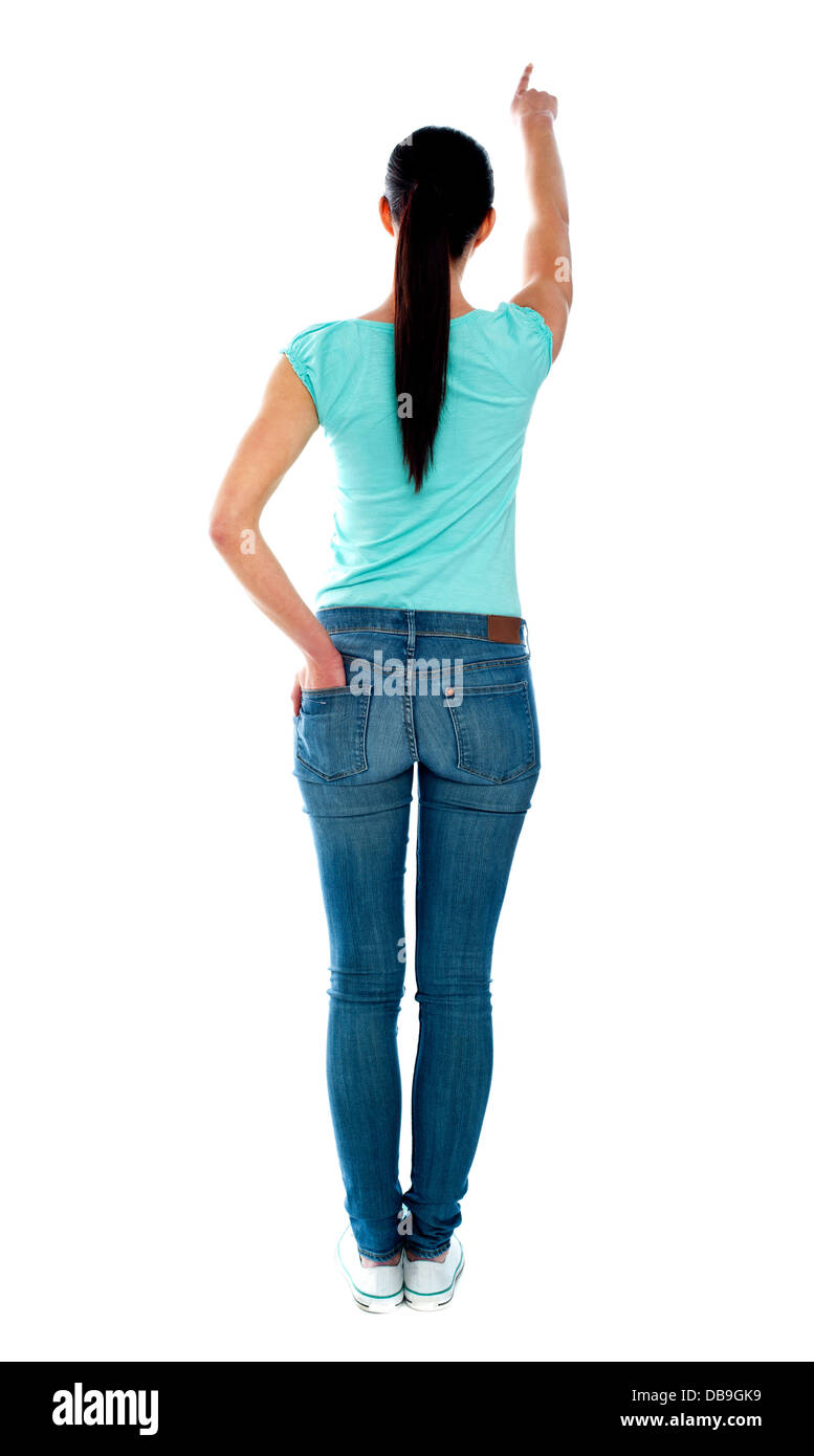 Rear view of young woman in casuals, pointing Stock Photo