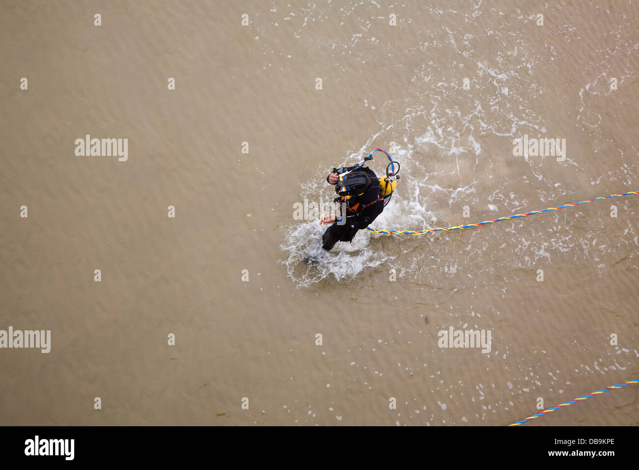 Diver walking into sea in full equipment UK Stock Photo
