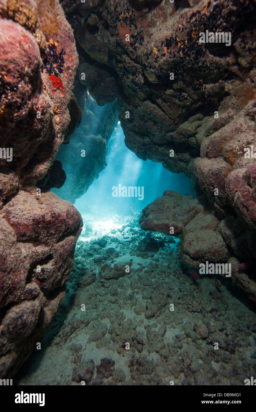Sunlight streaming through an underwater cave in tropical coral reef Stock Photo