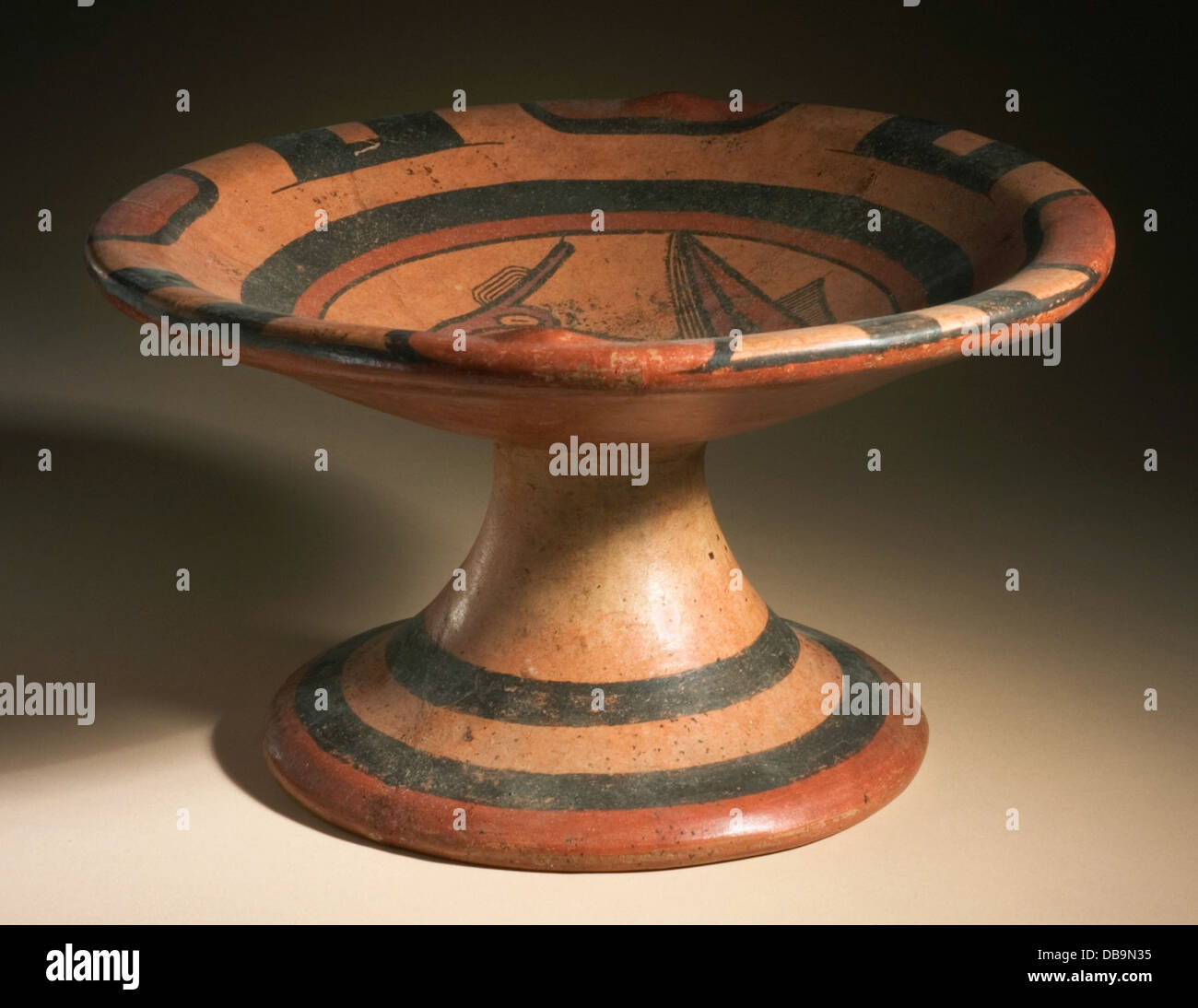 This pedestal dish, crafted in fine ceramics, features a distinct ray design on its surface. The dish represents the mastery of ancient potters, combining function with art. It is part of the museum's collection, showcasing the skill and artistry of pottery traditions from various cultures. Stock Photo