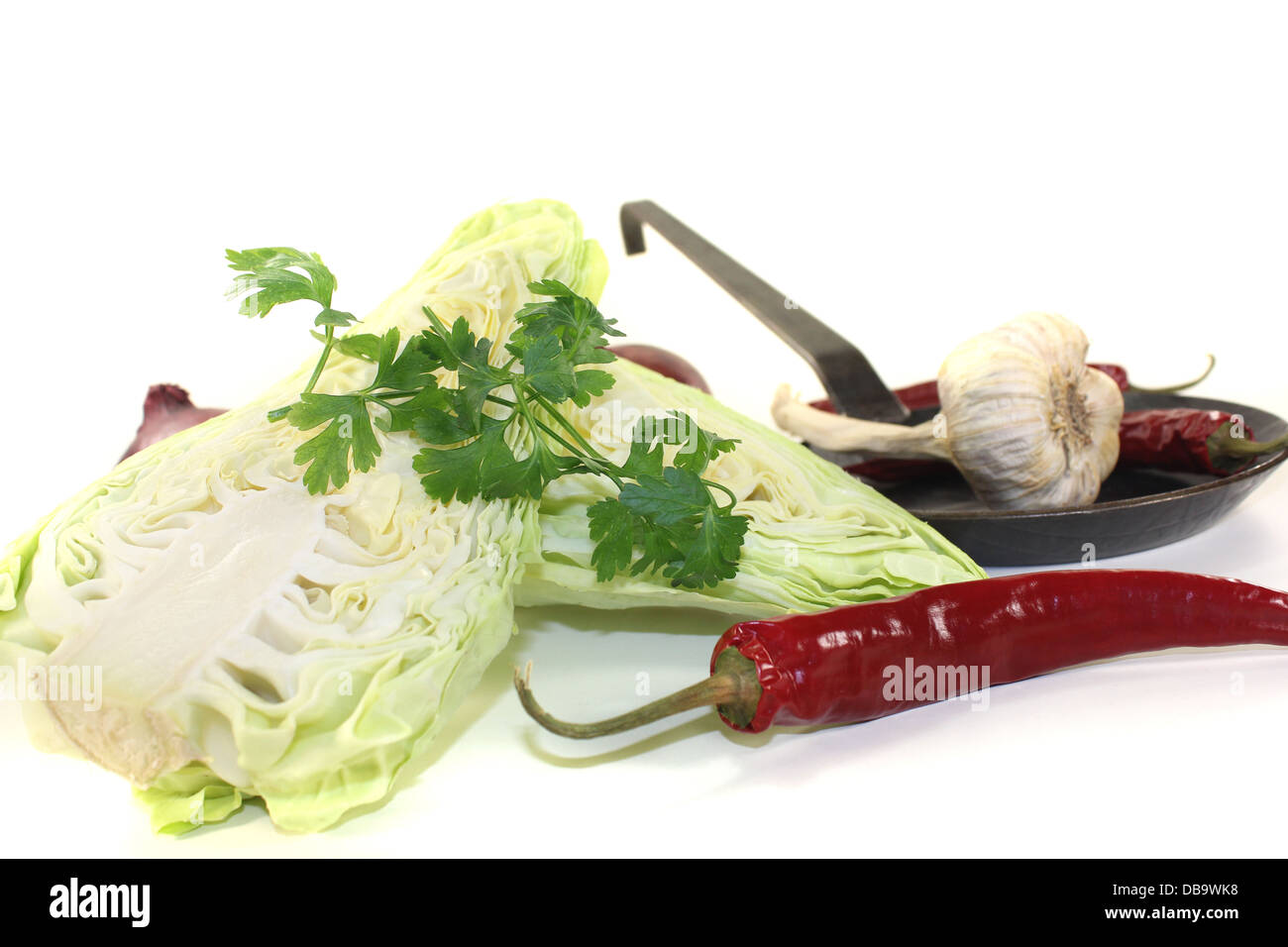 sweetheart cabbage with parsley, peppers and onions on a light background Stock Photo