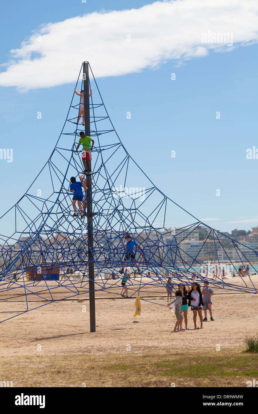 children playing on beach climbing frame Stock Photo