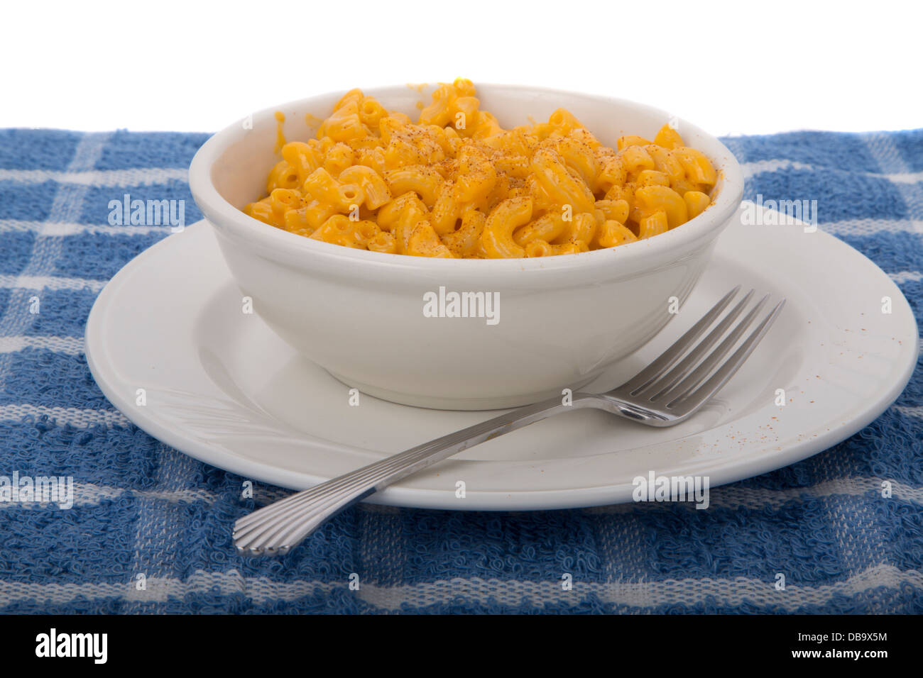 Macaroni and Cheese made from packaged mix in white bowl on a blue placemat Stock Photo